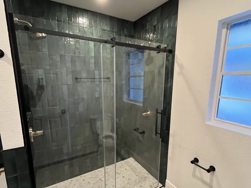 Master bathroom with tiled walk-in shower and double vanity.