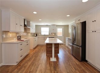 Renovated kitchen with white cabinetry and a center island