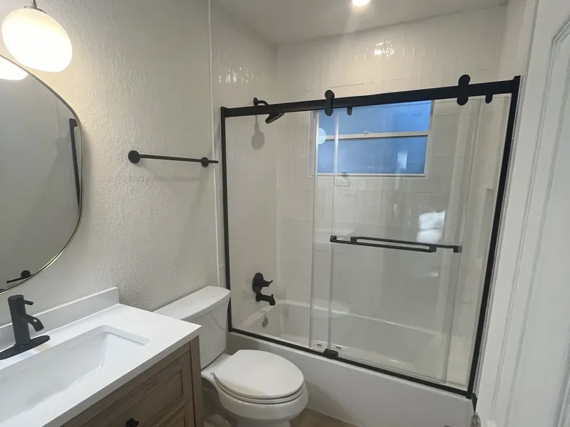 A remodeled bathroom with tiled walk-in shower.